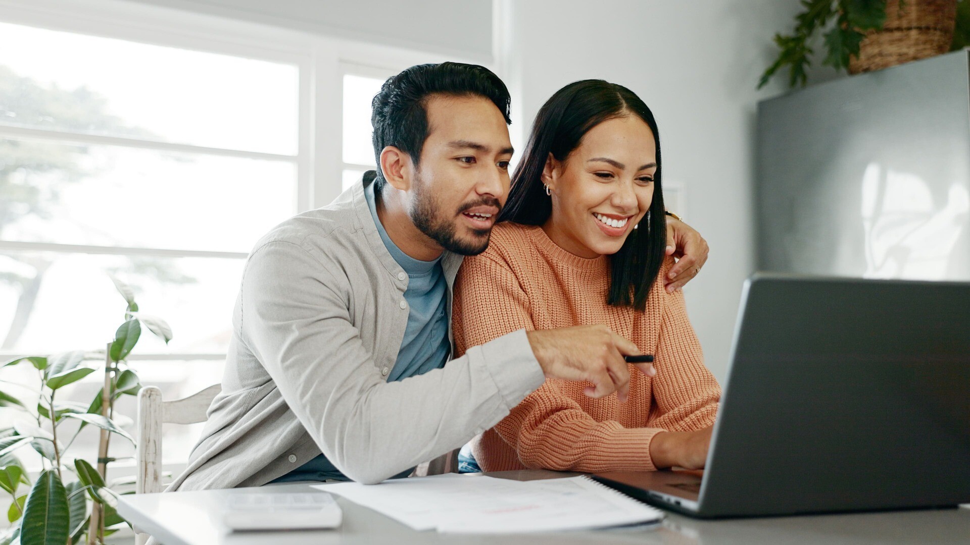 Ein Paar sitzt gemeinsam vor einem Laptop.