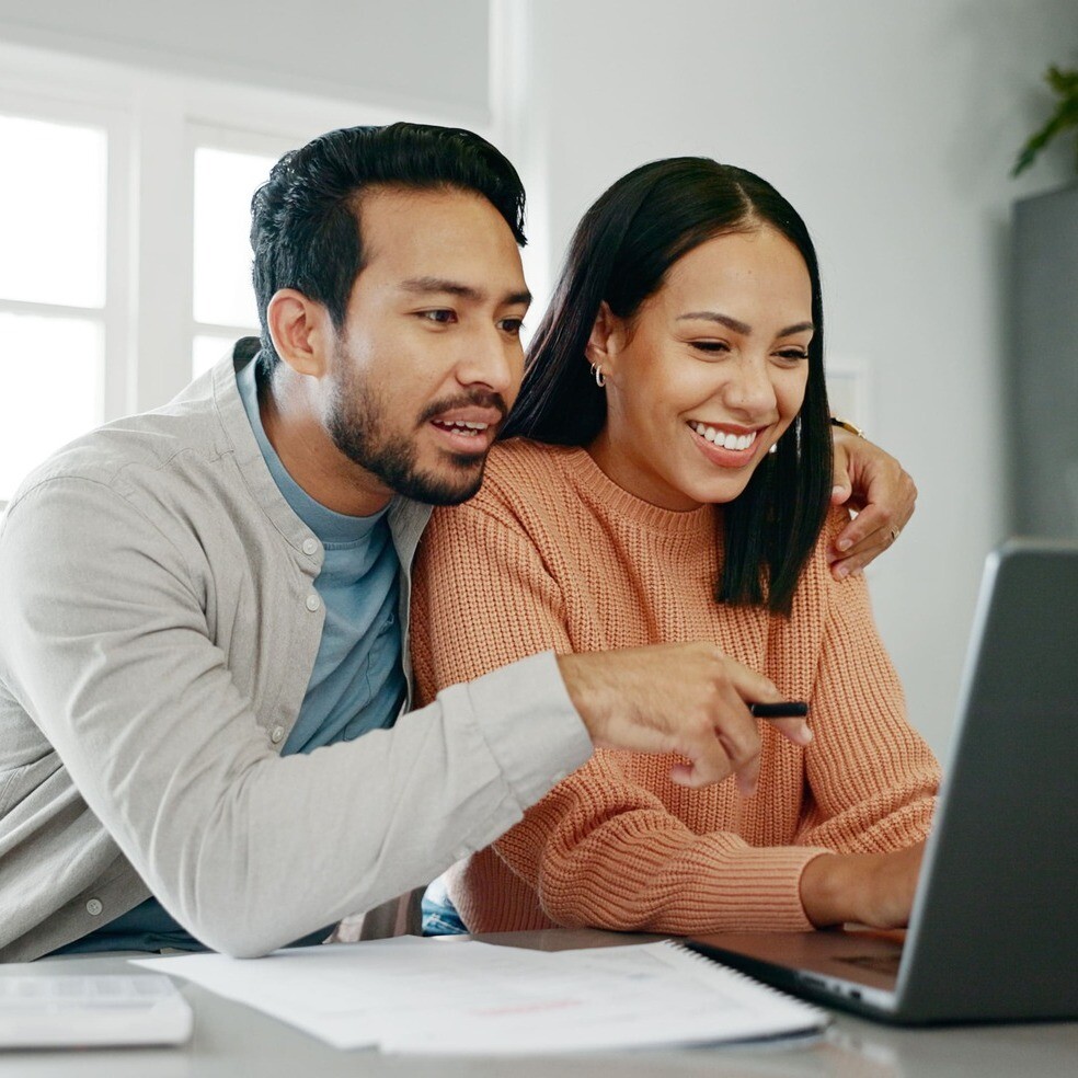 Paar sitzt gemeinsam vor Laptop