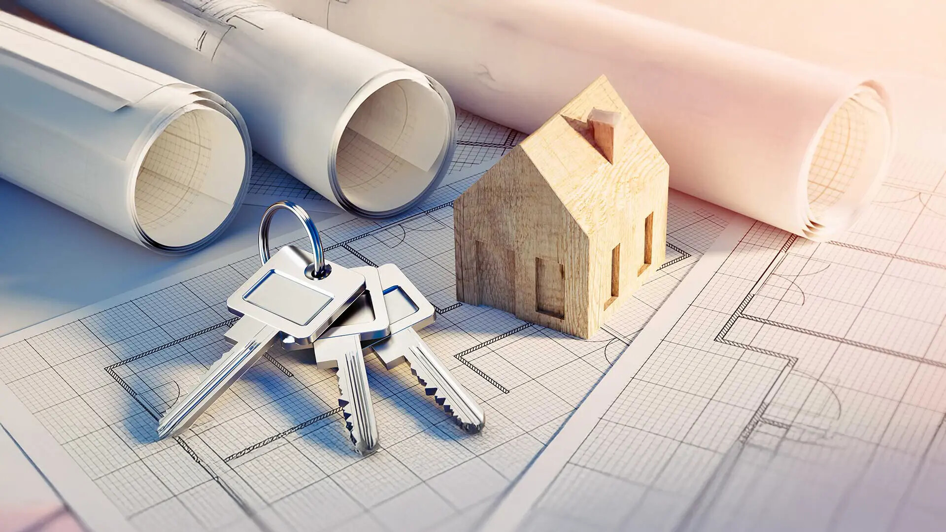 Schlüssel und ein Holzhausmodell auf architektonischen Entwürfen.