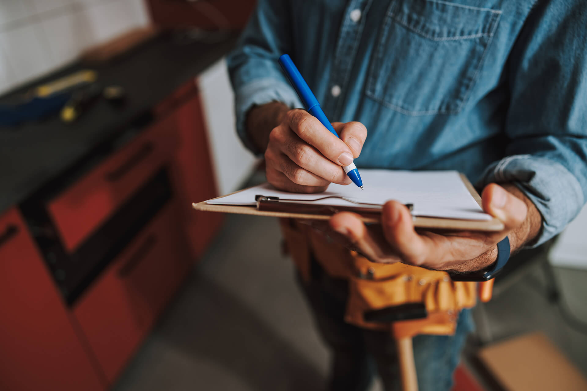 Ein Handwerker notiert etwas auf einem Kleppbrett
