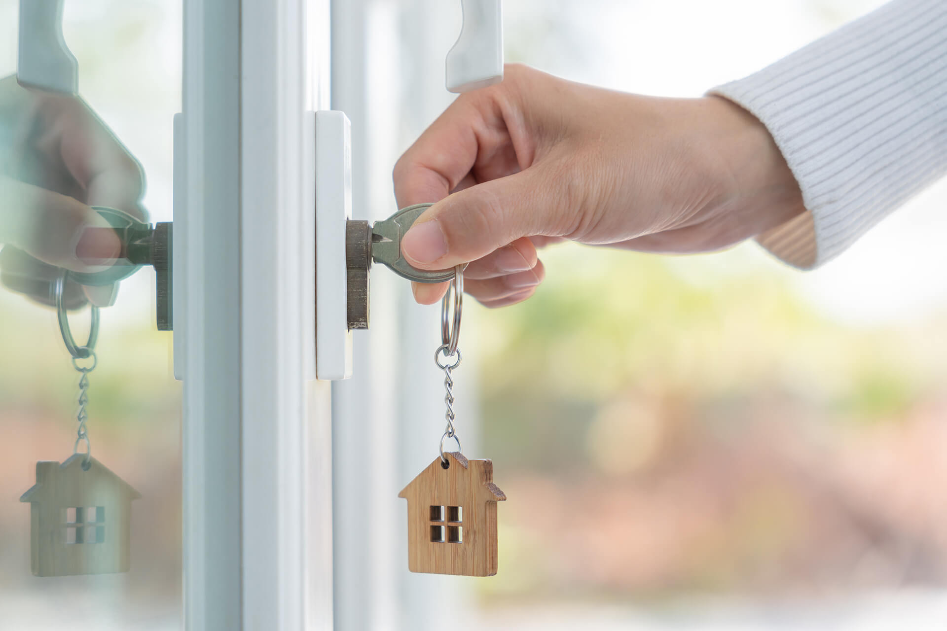 Person steckt Schlüssel in ein Schloss