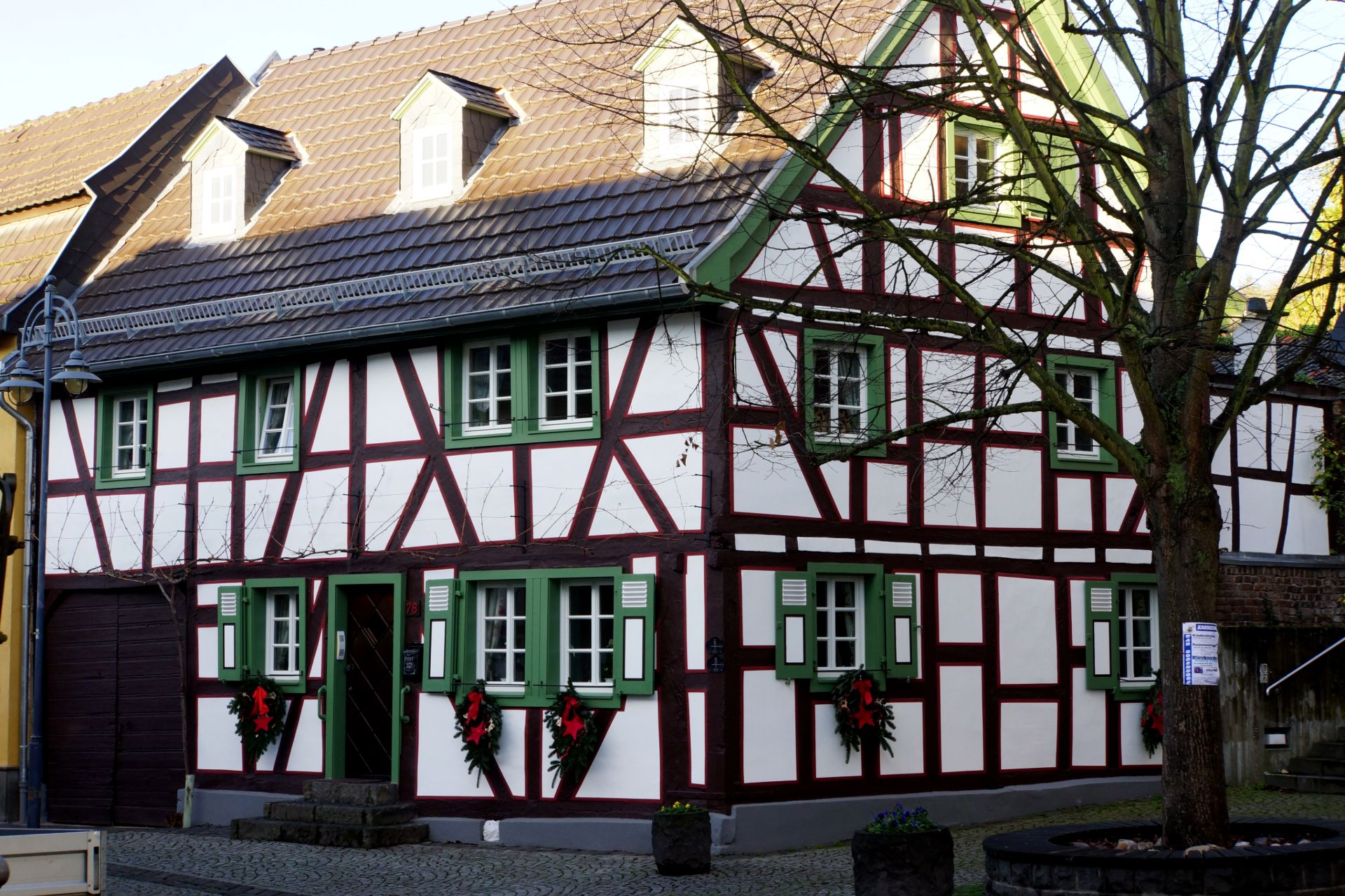 Historisches, restauriertes Fachwerkhaus mit grün gestrichenen Fensterläden und traditionellem Baustil.