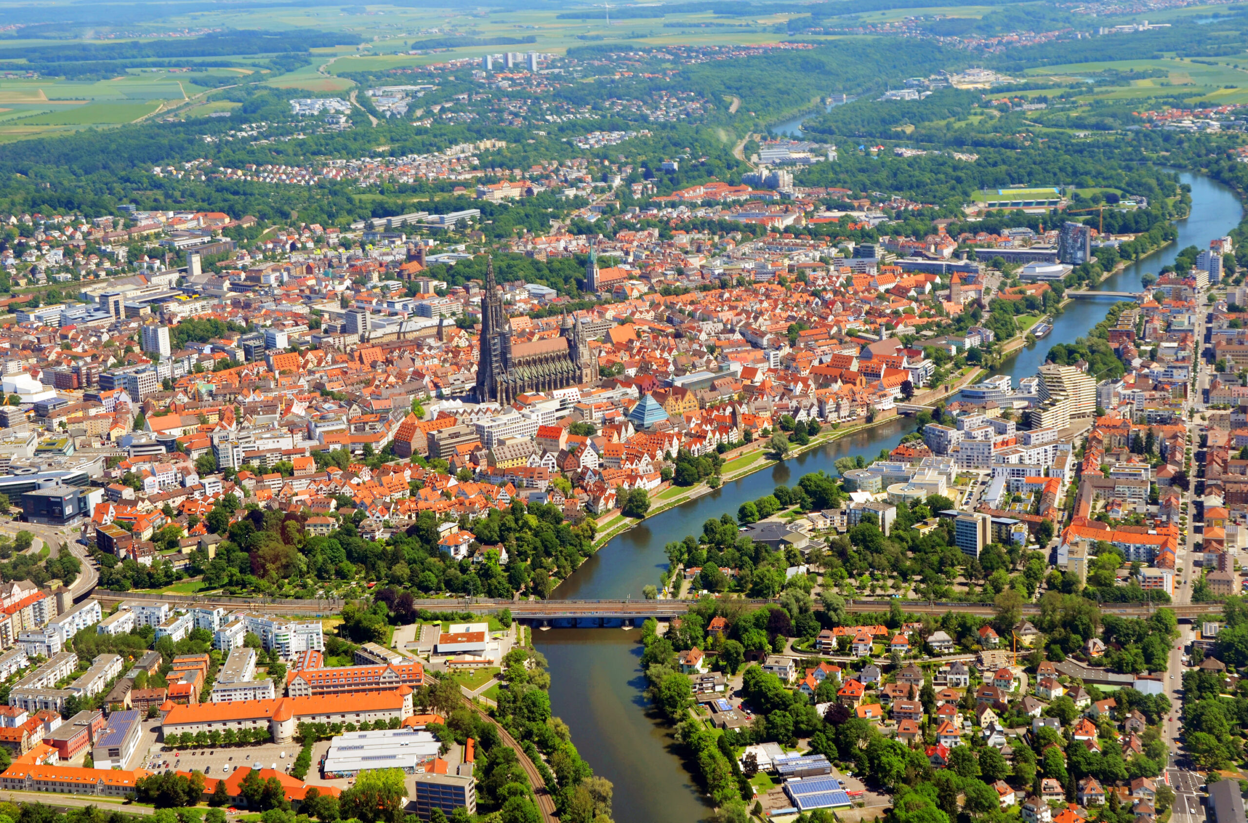Stadt mit Fluss, roten Dächern und zentralem Dom.
