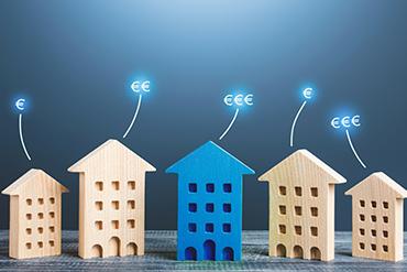 Fünf Holzhaus-Modelle, blaue und natürliche Farben, Euro-Symbole.