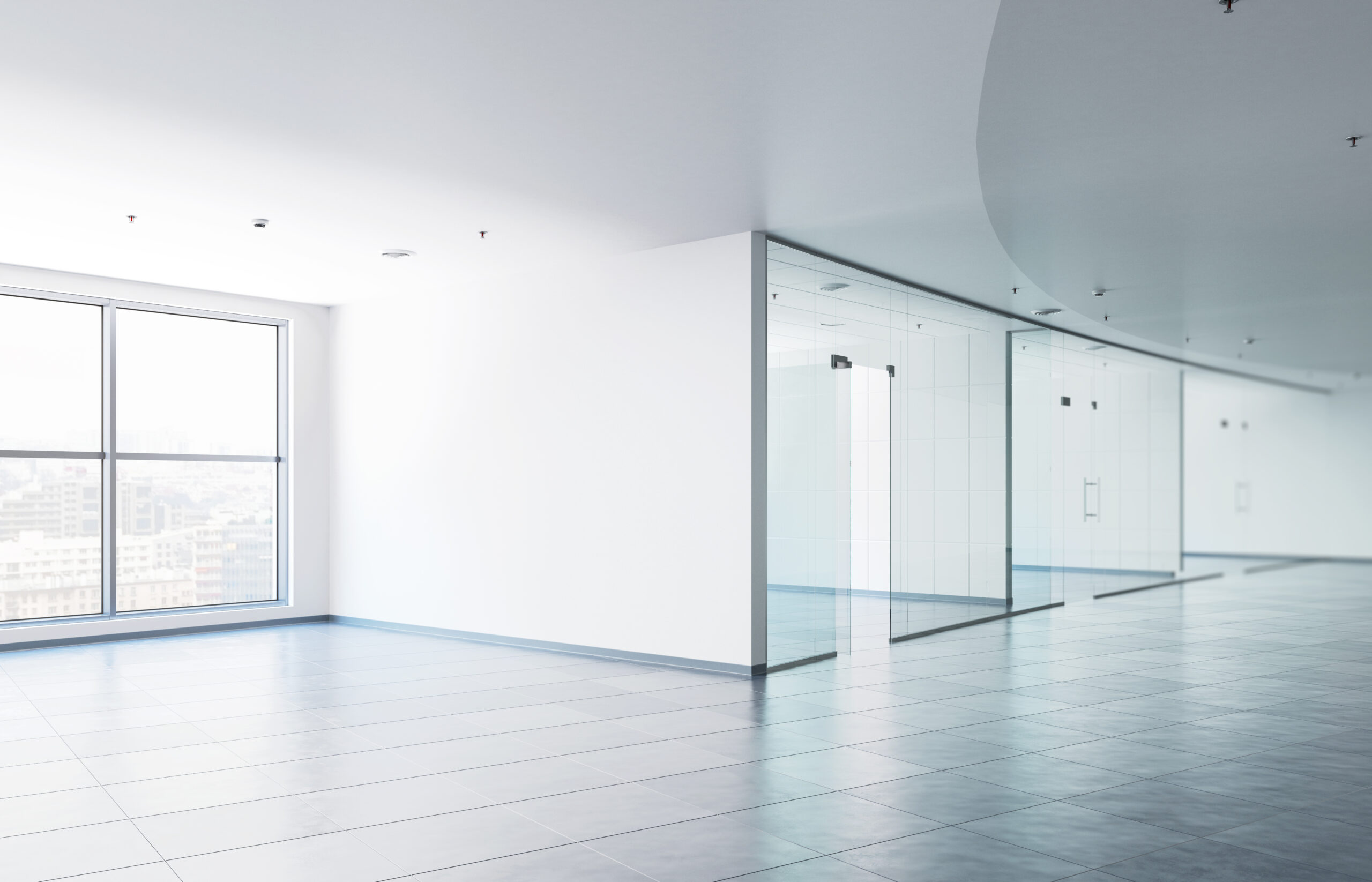 Leeres Büro mit großen Fenstern, Fliesenboden und Glaswänden.