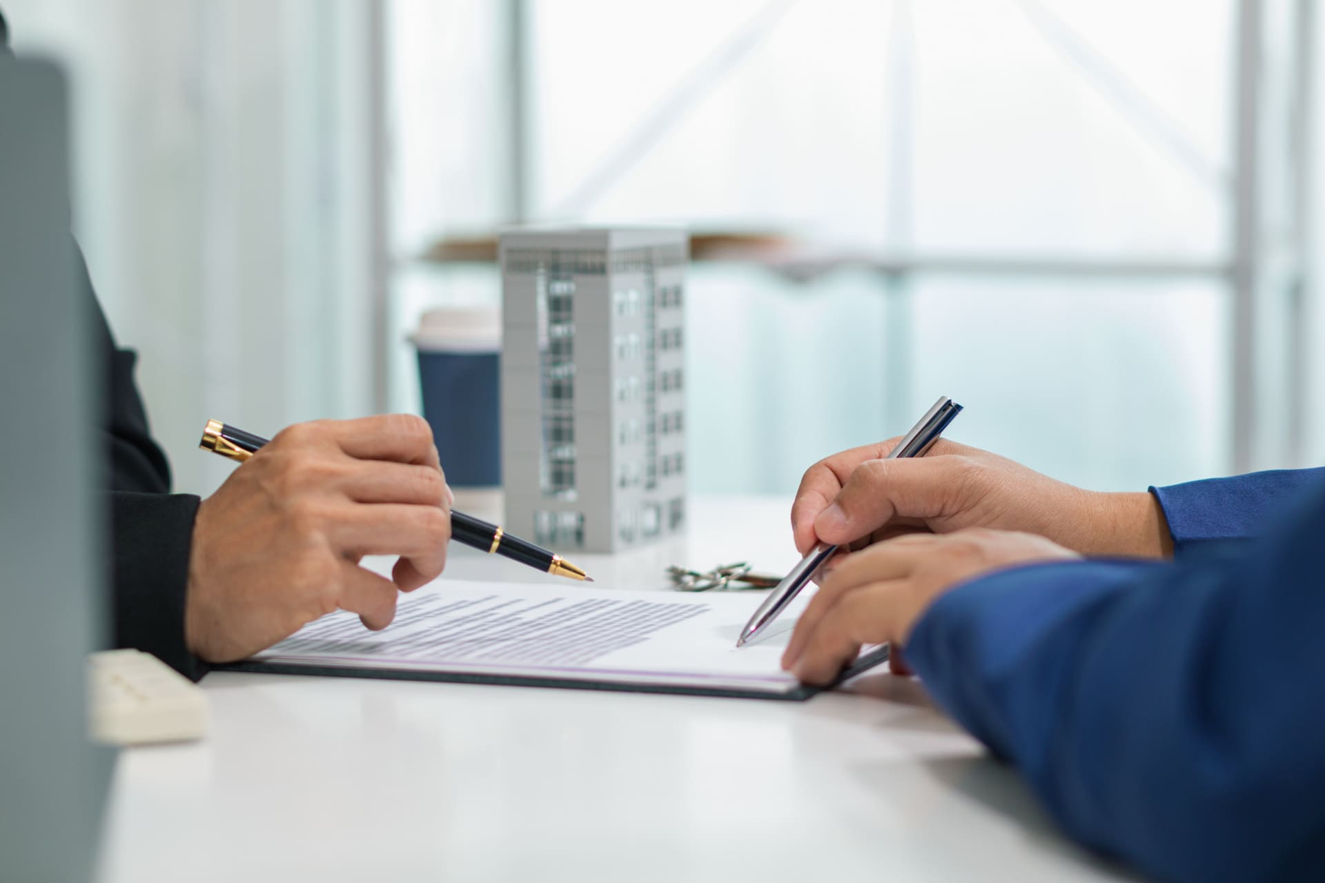 Immobilienmakler präsentiert Angebot und erklärt Vertrag im Büro.