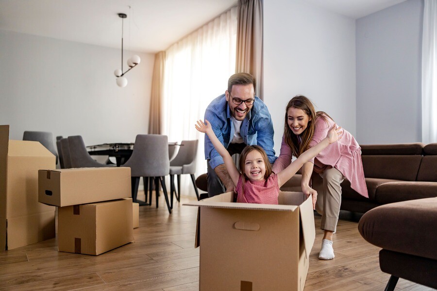 Glückliche Familie spielt mit Umzugskartons