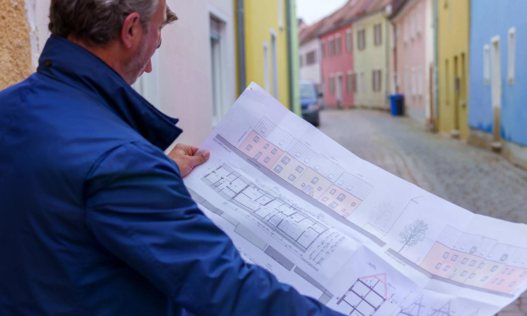 Markus Rätzer hält Baupläne