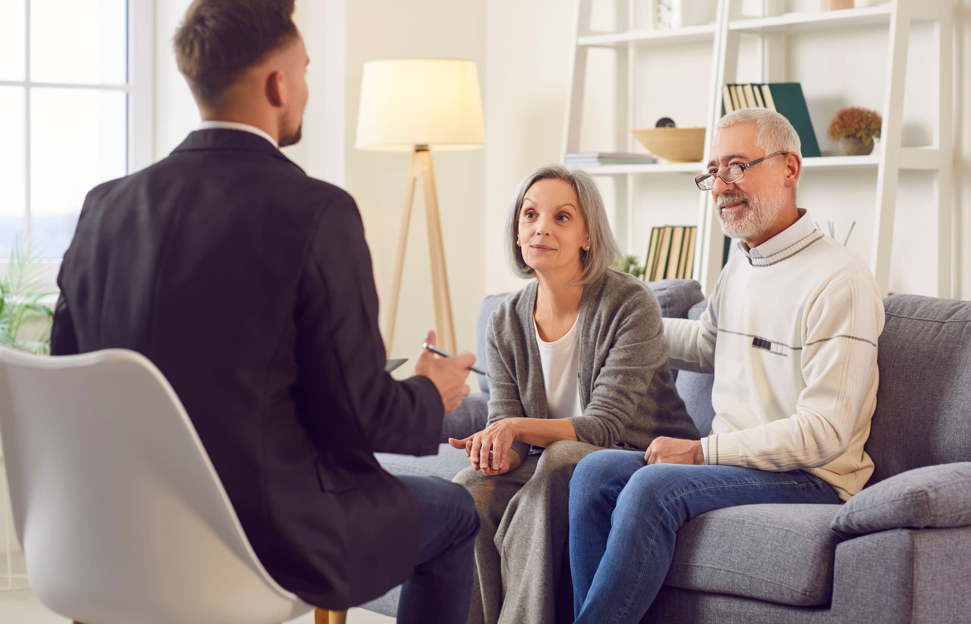 Berater erklärt Seniorenpaar Finanzplanung und Immobilienoptionen zu Hause.