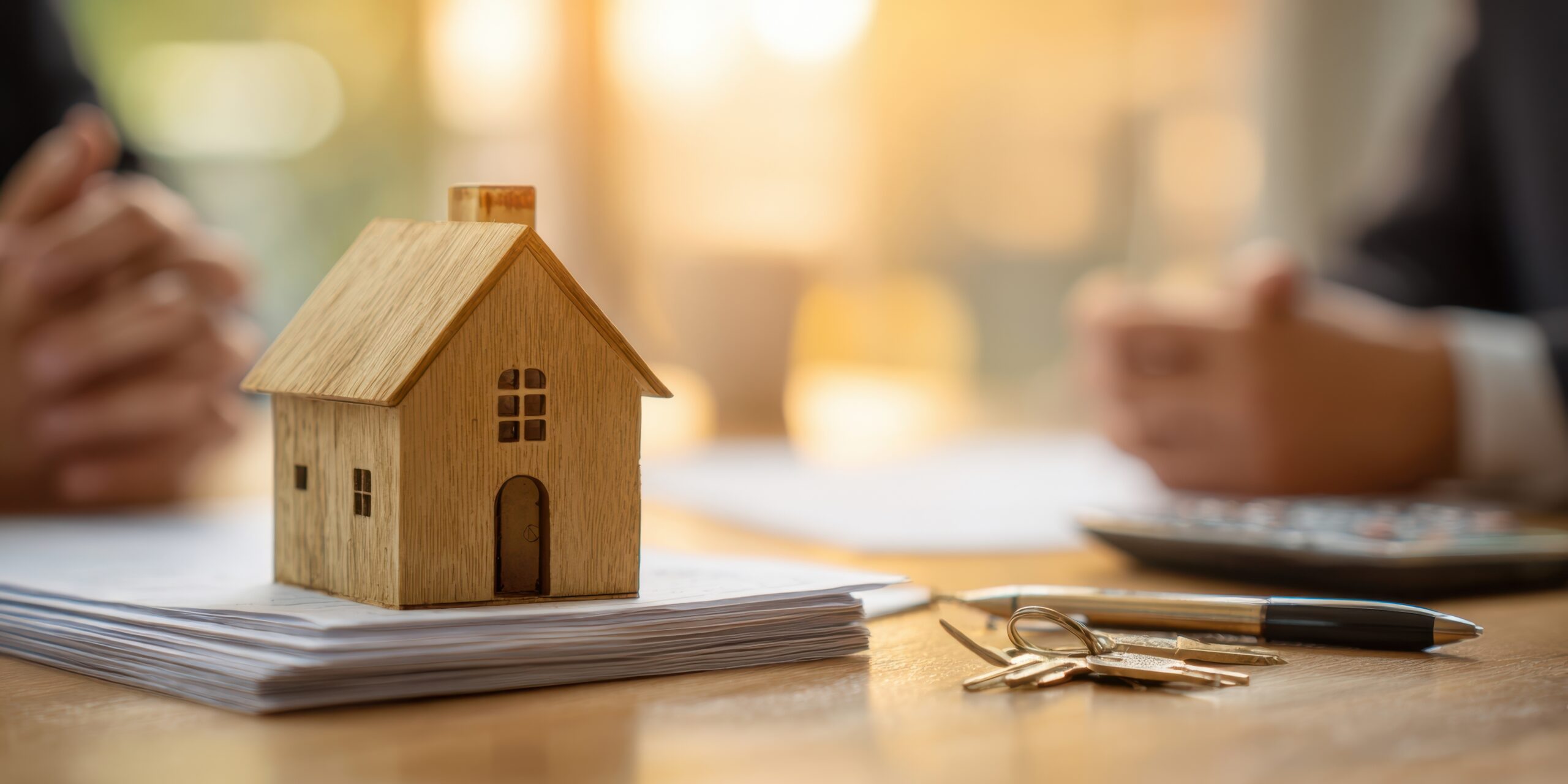 Holzhaus-Modell auf Papier und mit Schlüsseln