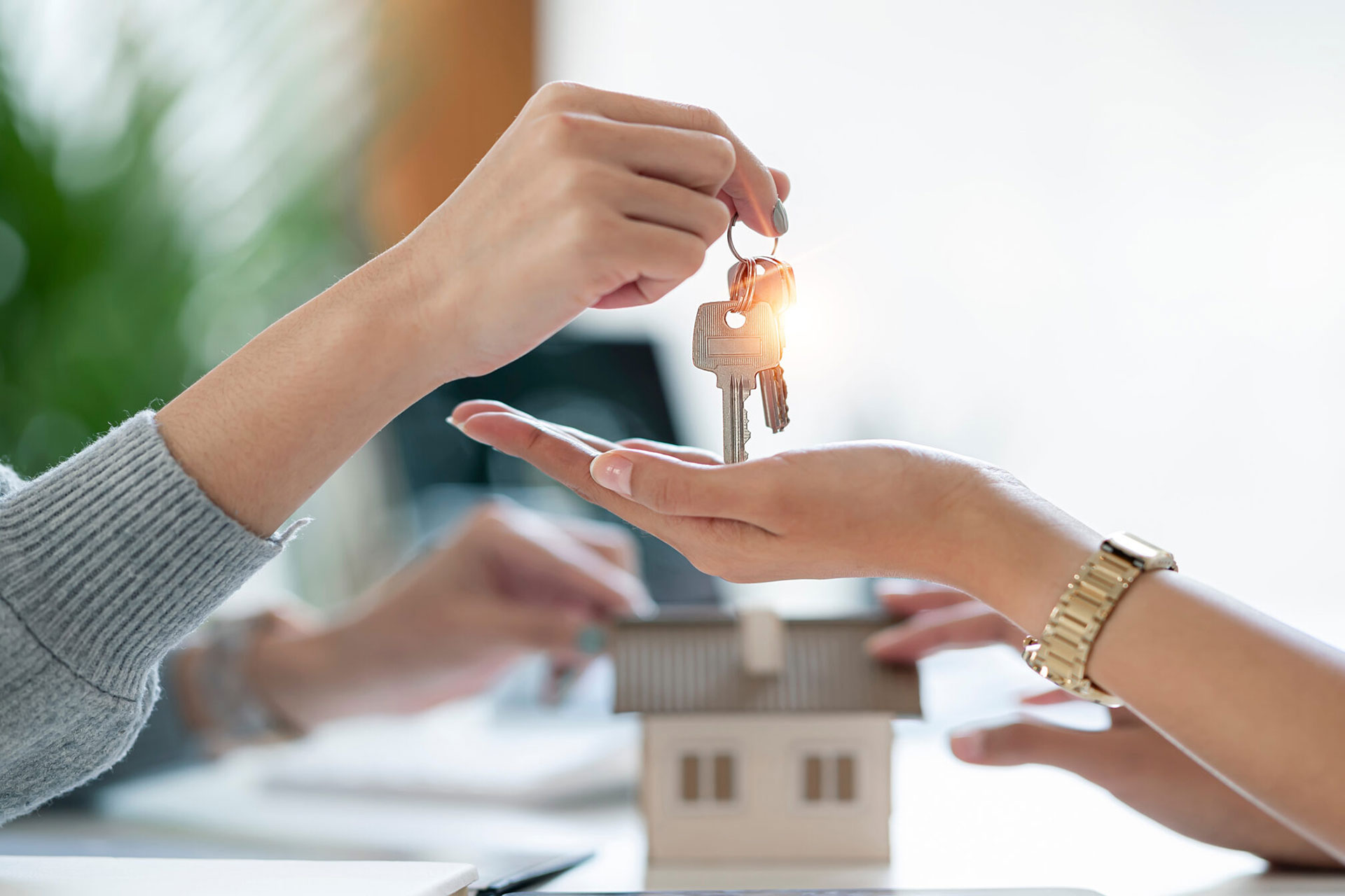 Immobilienmaklerin überreicht einer Kunden den Hausschlüssel