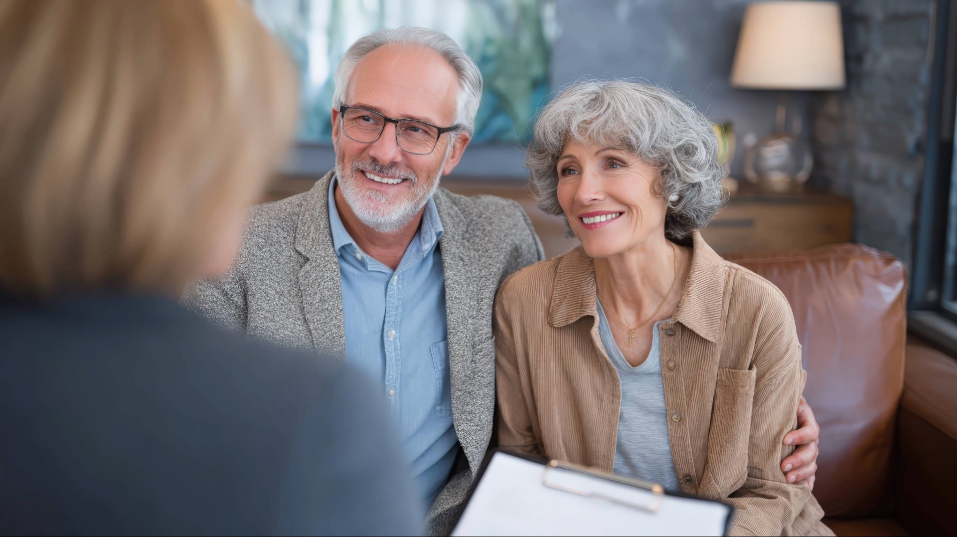 Glückliches Seniorenpaar bei einem Beratungsgespräch zur Immobilienrente oder Altersvorsorge.