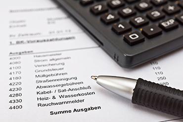 Taschenrechner und Kugelschreiber liegen auf einer Nebenkostenabrechnung.