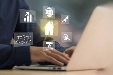 Eine Person sitzt an einem Laptop, darüber schweben digitale Buttons.