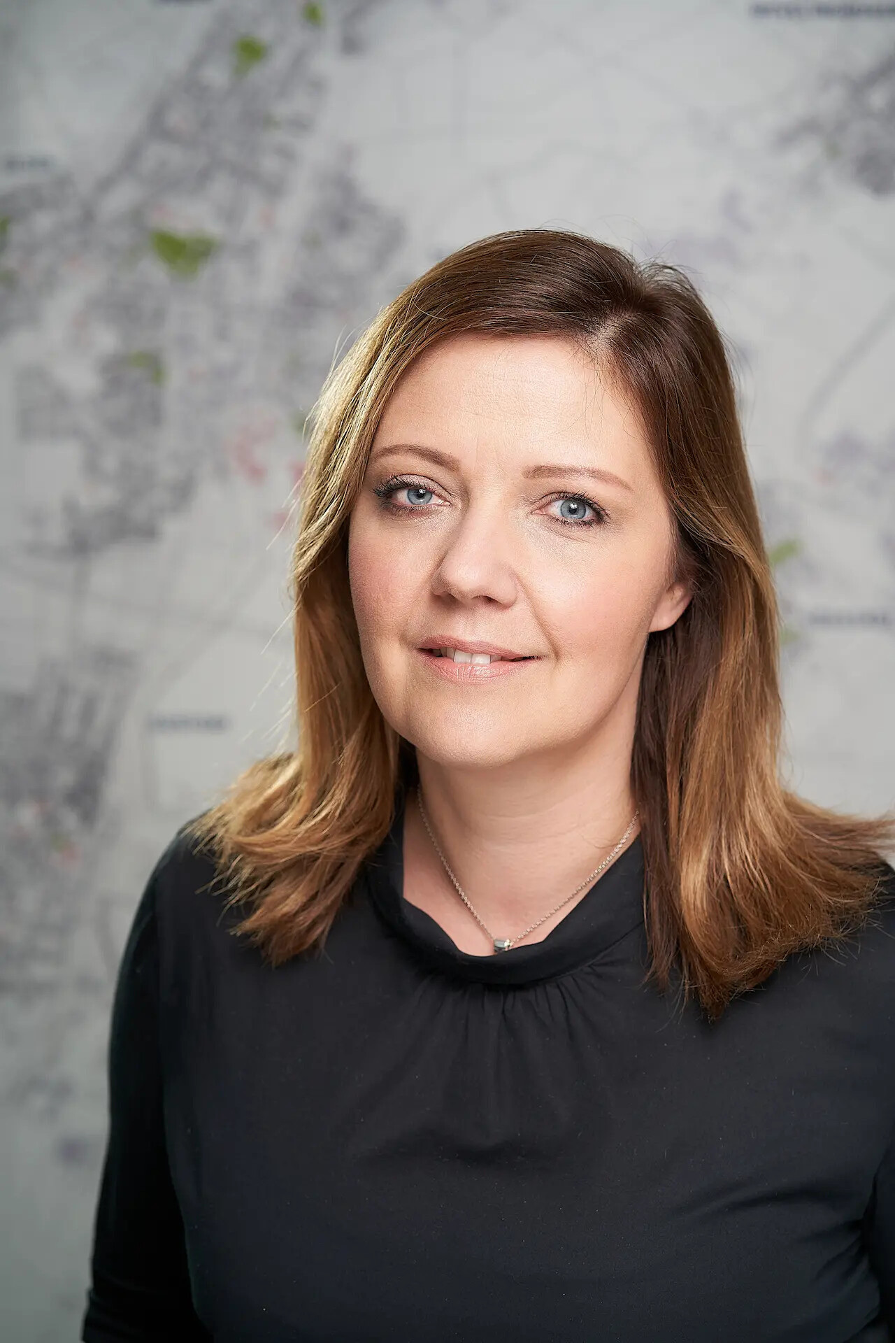 Miriam Trapp mit schwarzem Top vor unscharfer Karte.