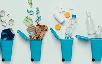 Beitragsbild zur Mülltrennung: verschiedene Mülltonnen werden mit verschiedenen Materialien befüllt