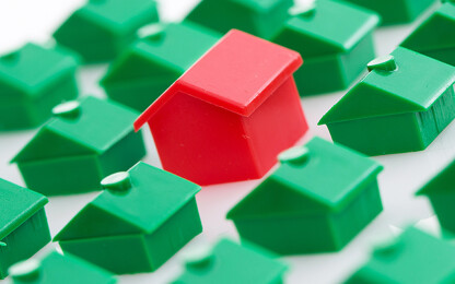 viele grüne und ein rotes Haus aus Monopoly