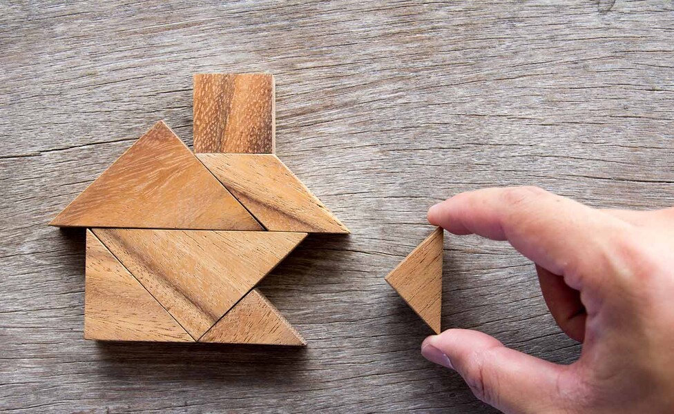 Puzzle aus mehreren Teilen ergibt ein Holzhaus