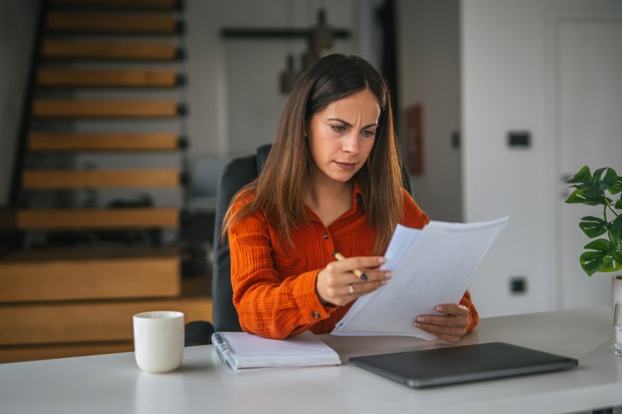 Eine Frau liest Unterlagen und guckt nachdenklich