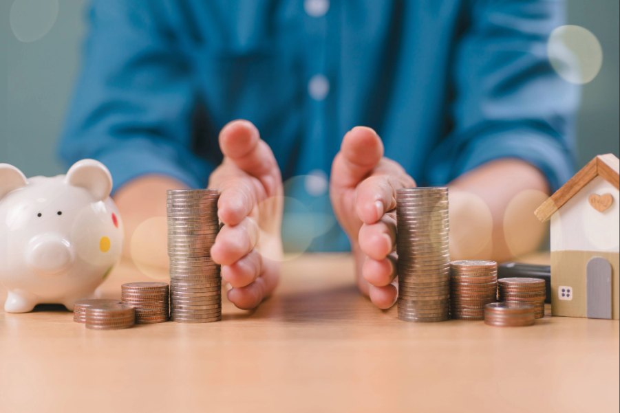 Eine Person teilt Geldmünzen mittig