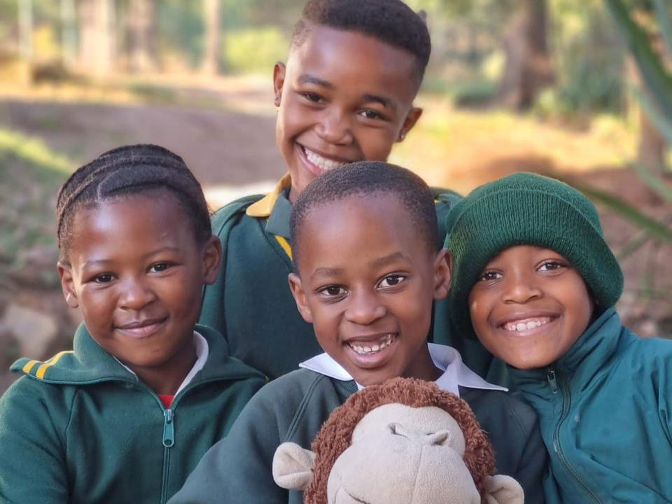 Vier Kinder mit Affenstofftier