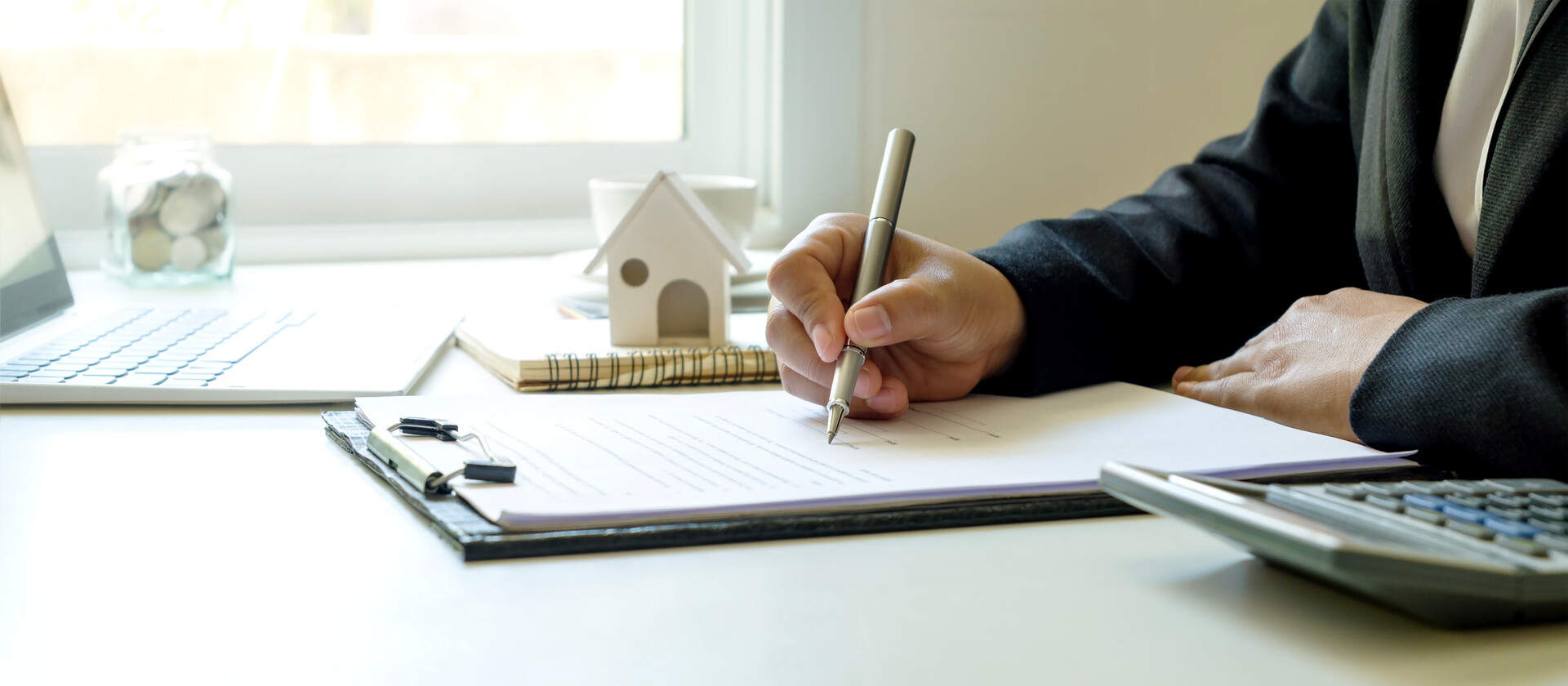 Mann unterschreibt Unterlagen am Schreibtisch