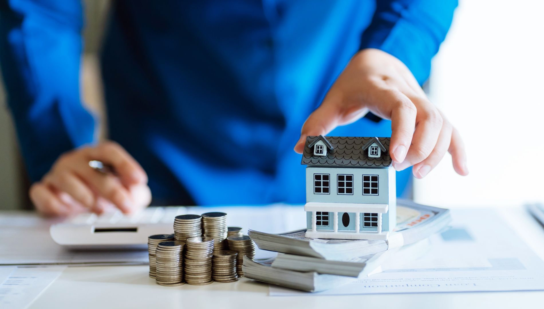 Modellhaus und Geld auf Schreibtisch