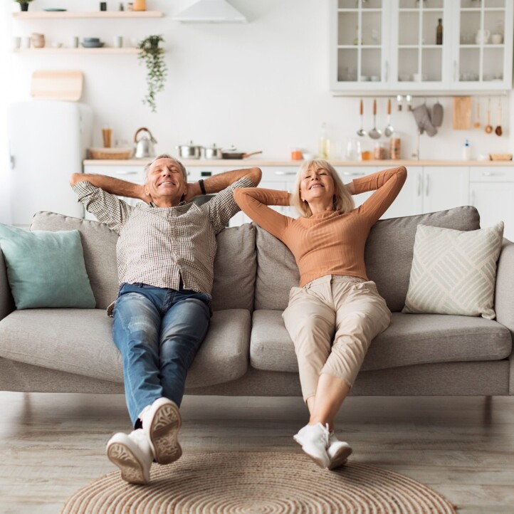 Senioren lehnen sich auf Sofa entspannt zurück