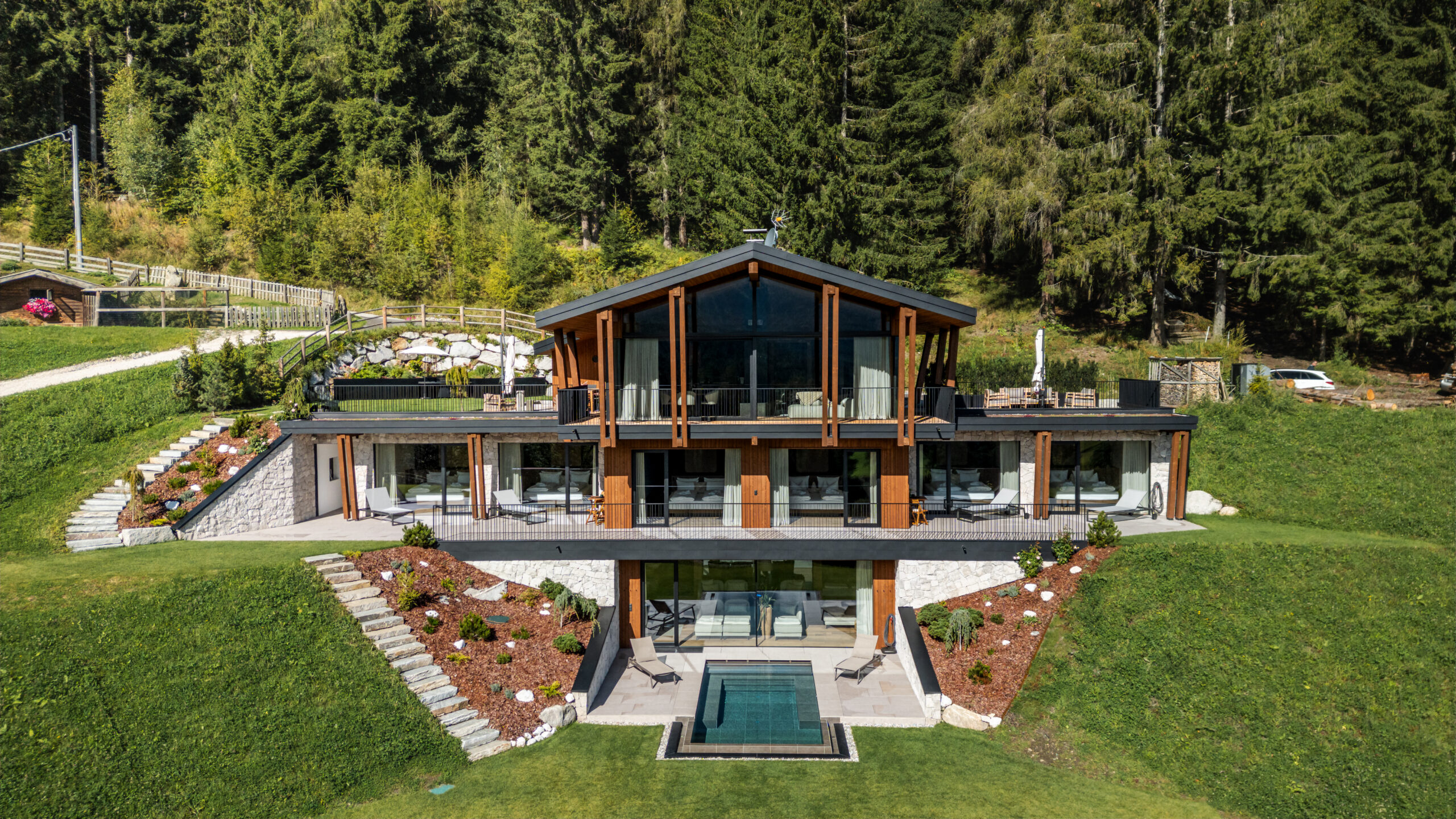 Modernes zweistöckiges Haus mit großen Fenstern und kleinem Pool.
