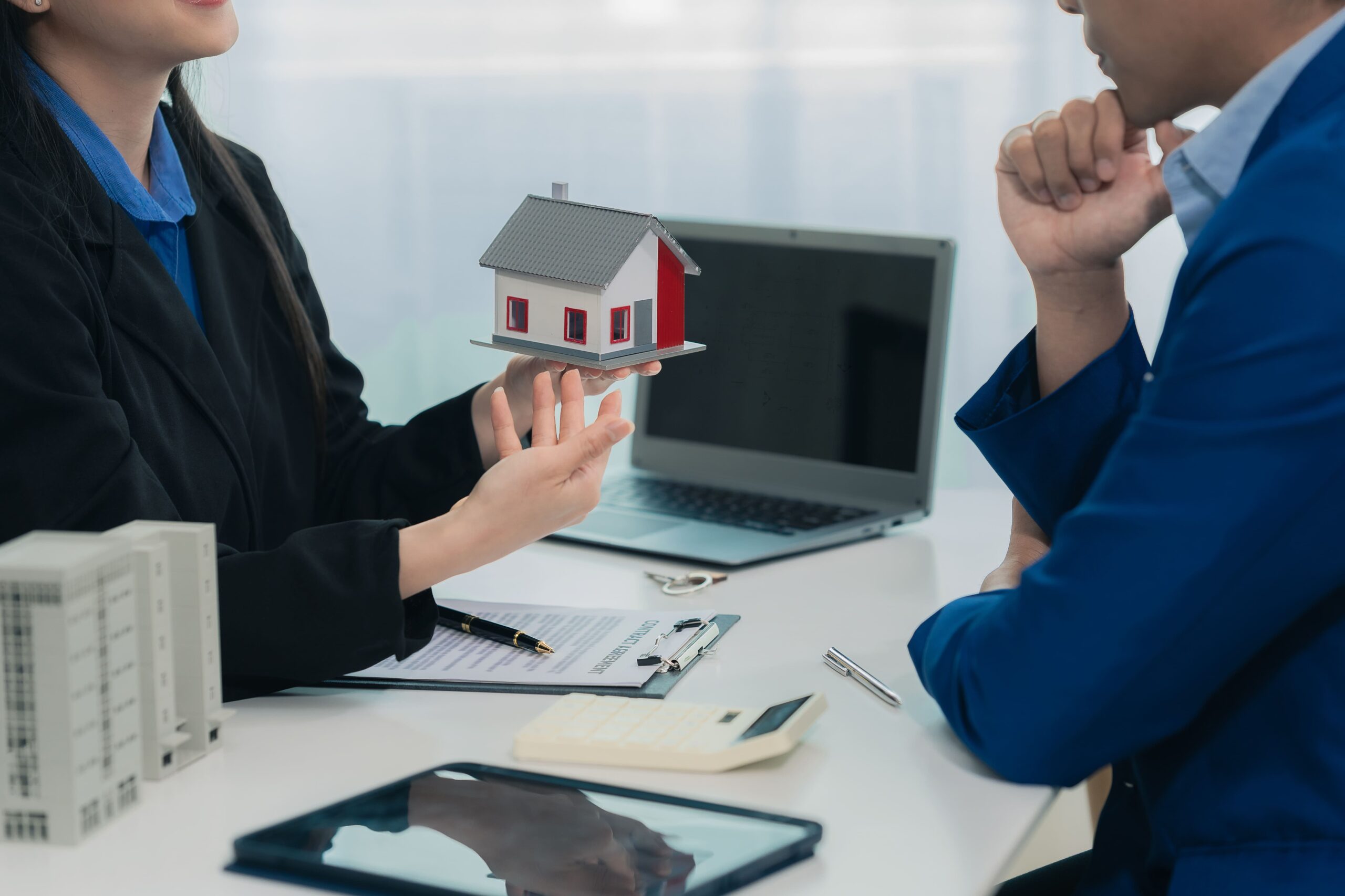 Makler unterhält sich mit Kunde über Haus