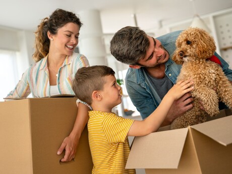 Glückliche Familie mit Hund und Umzugskartons