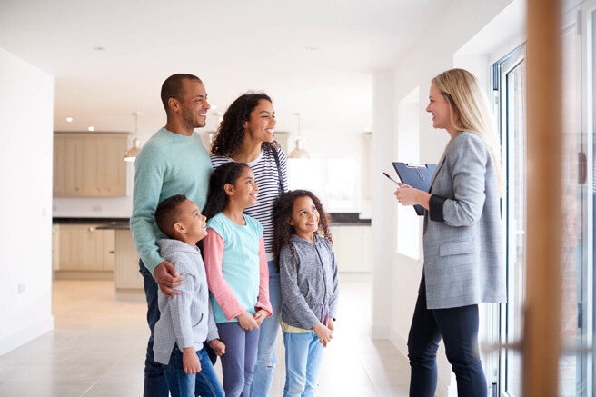 Junge Familie besichtigt Haus mit Maklerin