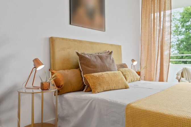 Beispiel der professionellen Fotografie: Gemütlich hergerichtetes Bett mit Tagesdecke