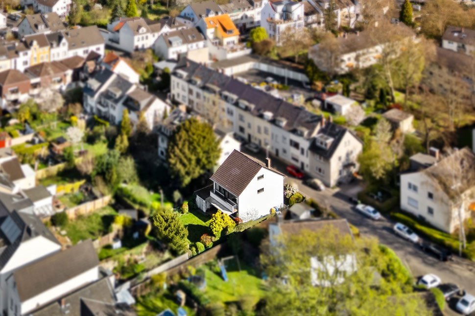 Beispielbild Drohnenaufnahme eines Einfamilienhauses, Nachbarschaft wurde für Privatsphäre unkenntlich gemacht