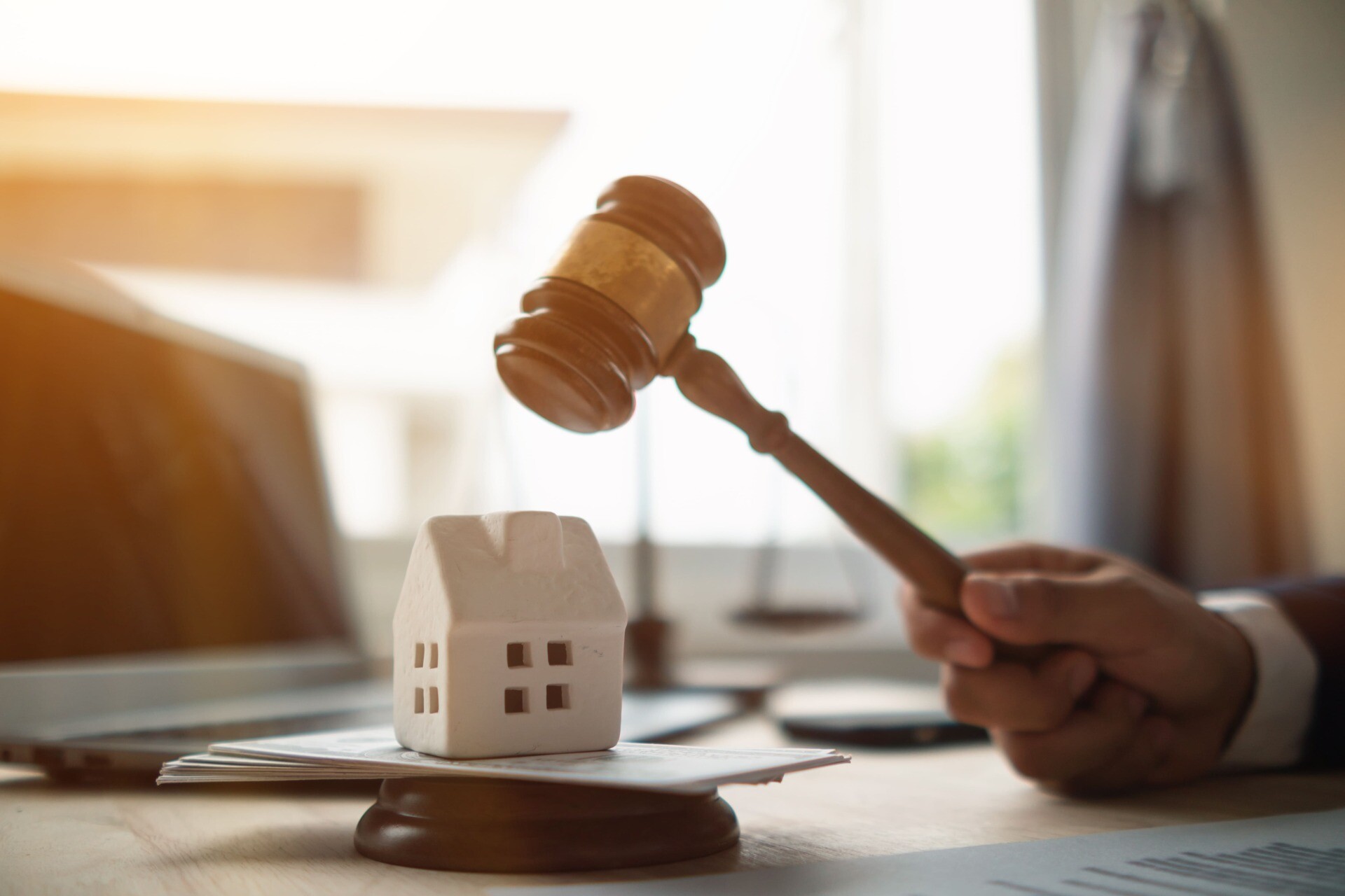 Modellhaus, Geld und Richterhammer als Symbol für die Zwangsversteigerung von Immobilien