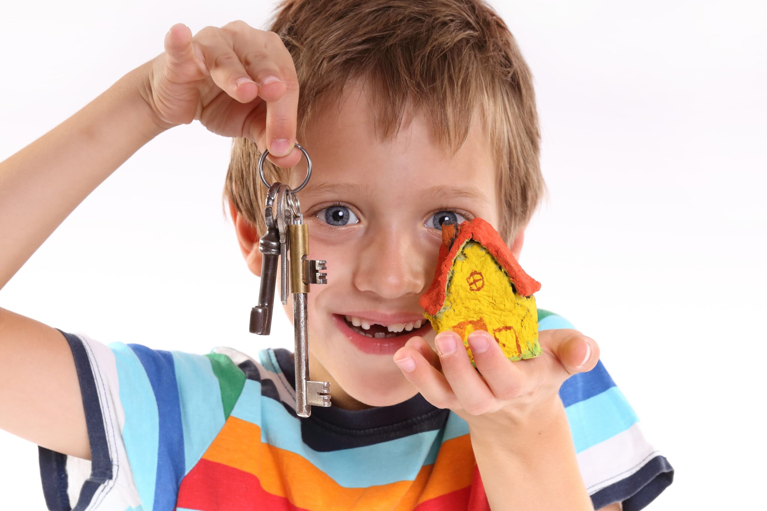 Kind mit Schlüsseln in einer Hand, Spielzeughaus in der anderen.