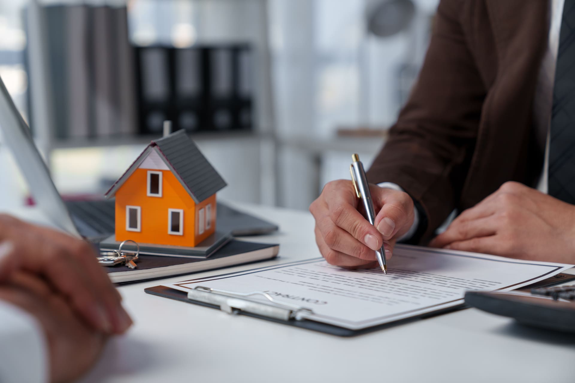 Kunde unterzeichnet Immobilienkaufvertrag beim Makler.