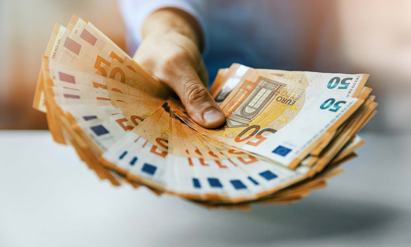 Person hält 50-Euro-Geldscheine in der Hand: Tippgeberprämie