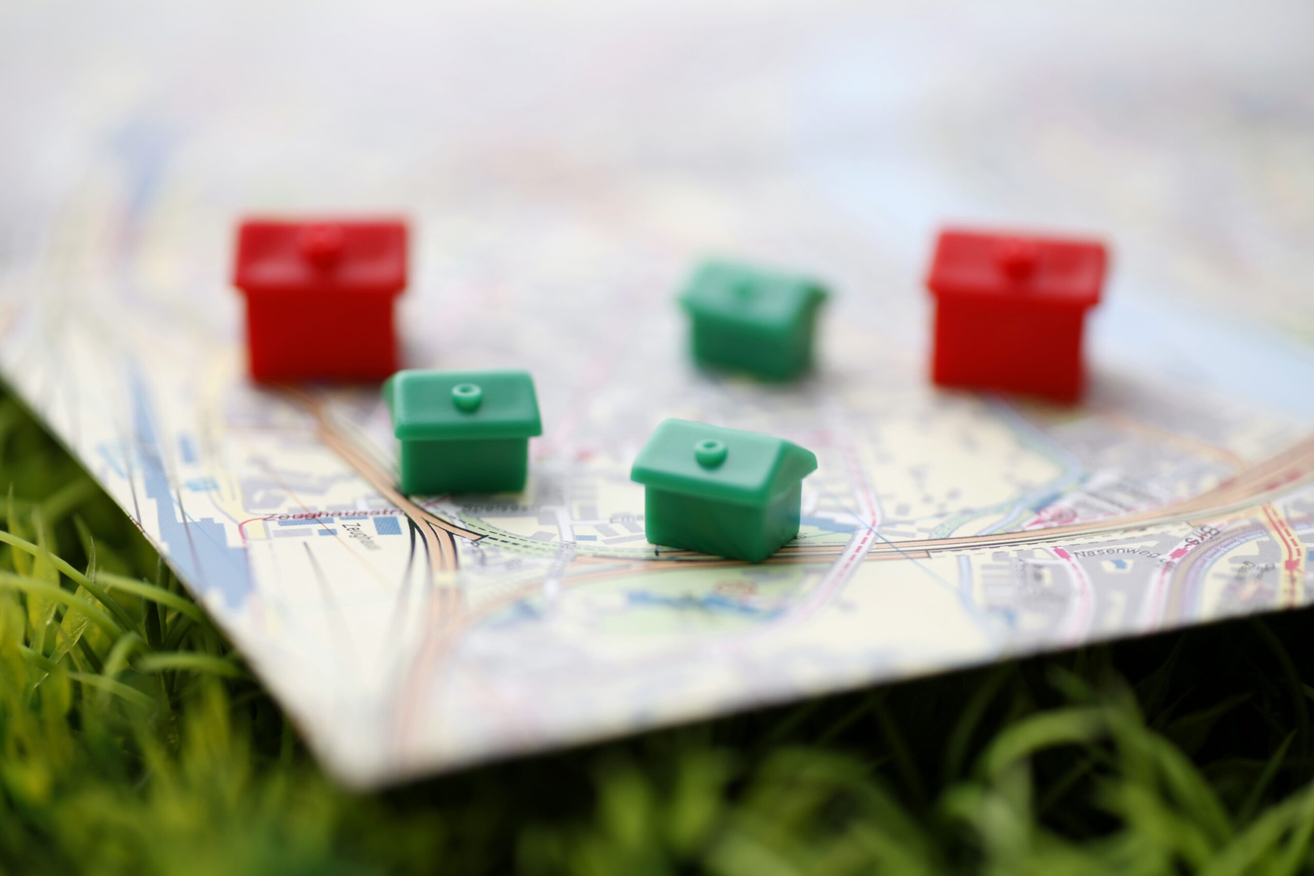 Rote und grüne Spielzeughäuser auf Spielfeld im Gras.