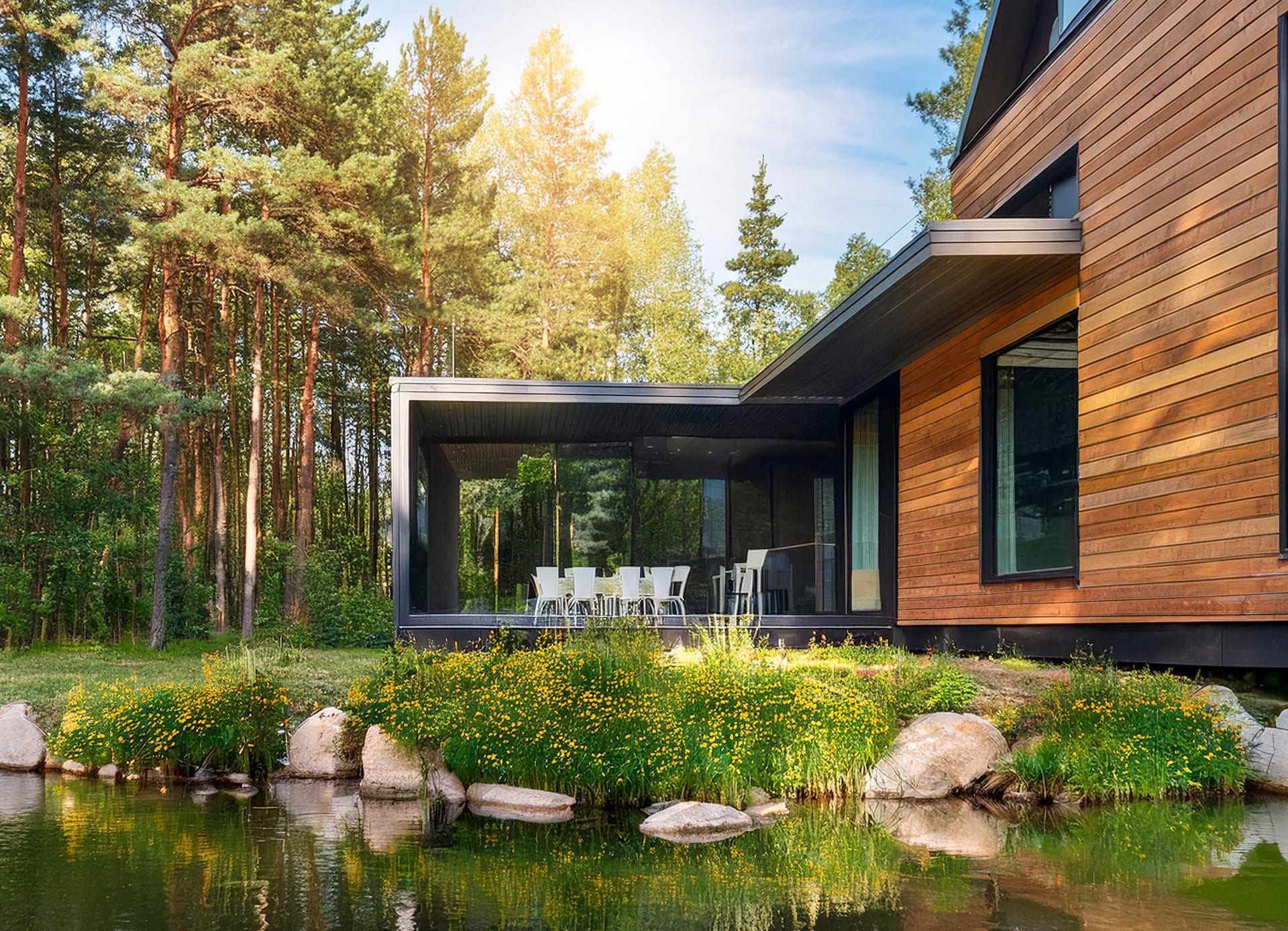 Neubau-Holzhaus mit großen Fenstern, Terrasse, Teich und viel Grün: Nachhaltigkeit beim Neubau