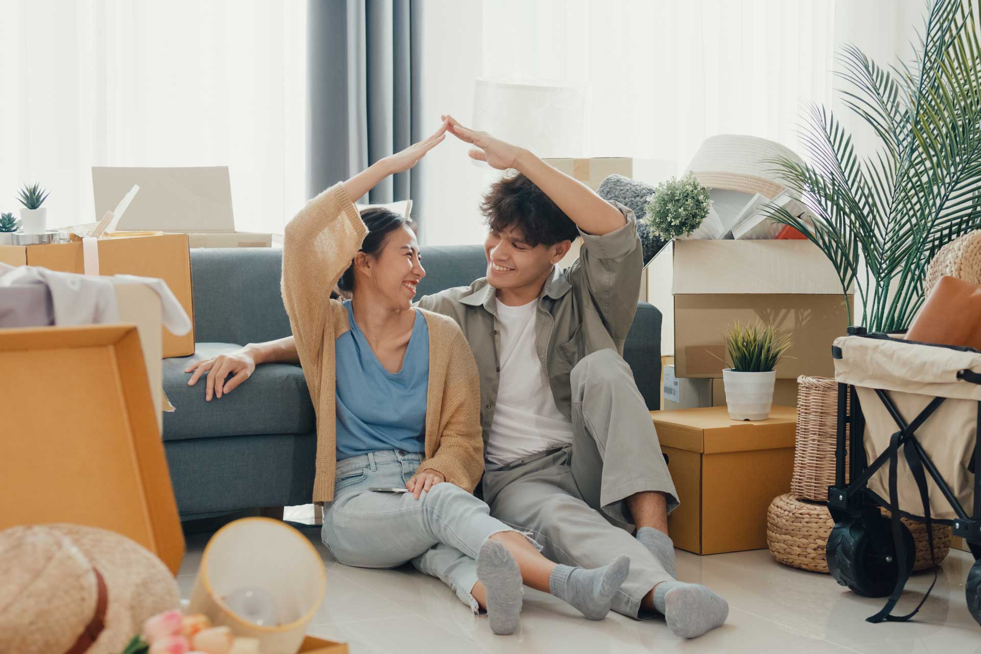 Paar formt mit den Armen ein Dach, symbolisiert Ablauf beim Hauskauf