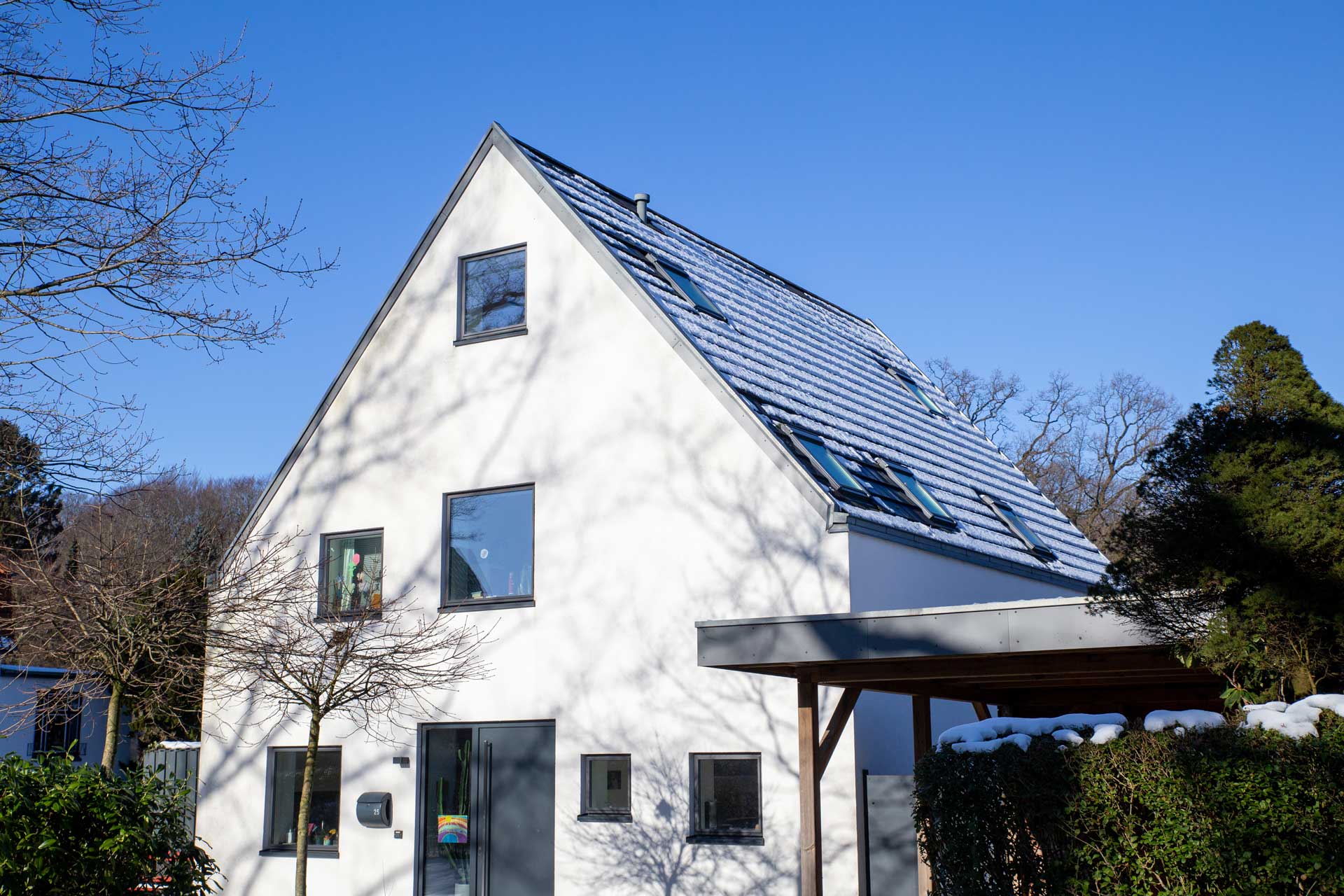 Winterschutz: Einfamilienhaus im Winter mit Schnee auf dem Dach