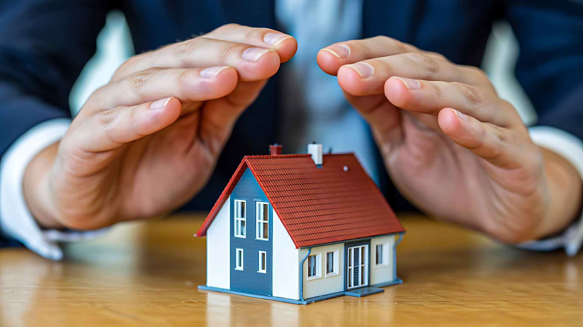 Schützende Hände über Modellhaus