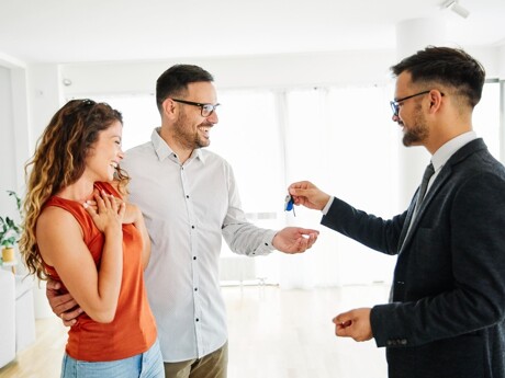 Makler übergibt Schlüssel an Paar