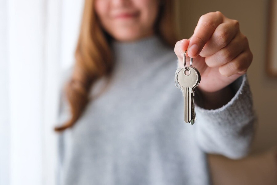 Eine Frau hält einen Schlüssel in der Hand