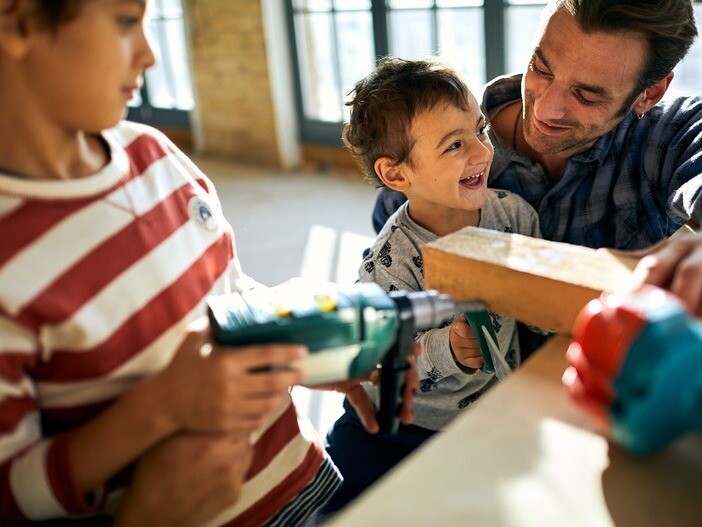 Mann mit zwei kleinen Kindern beim Renovieren
