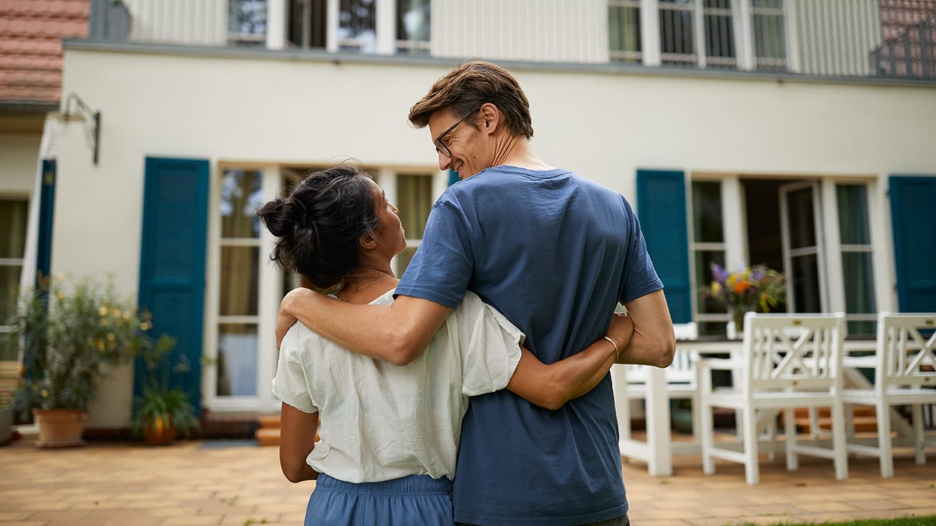 Paar steht vor ihrem neuen Haus