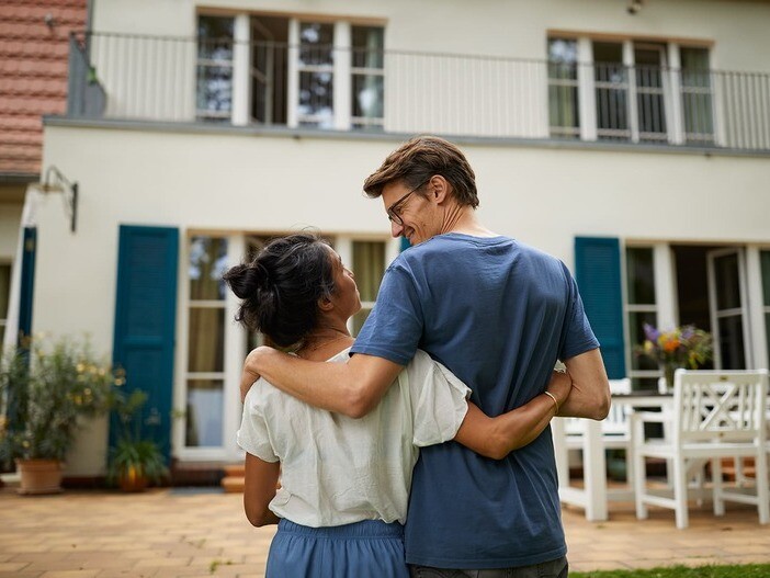 Paar steht vor ihrem neuen Haus