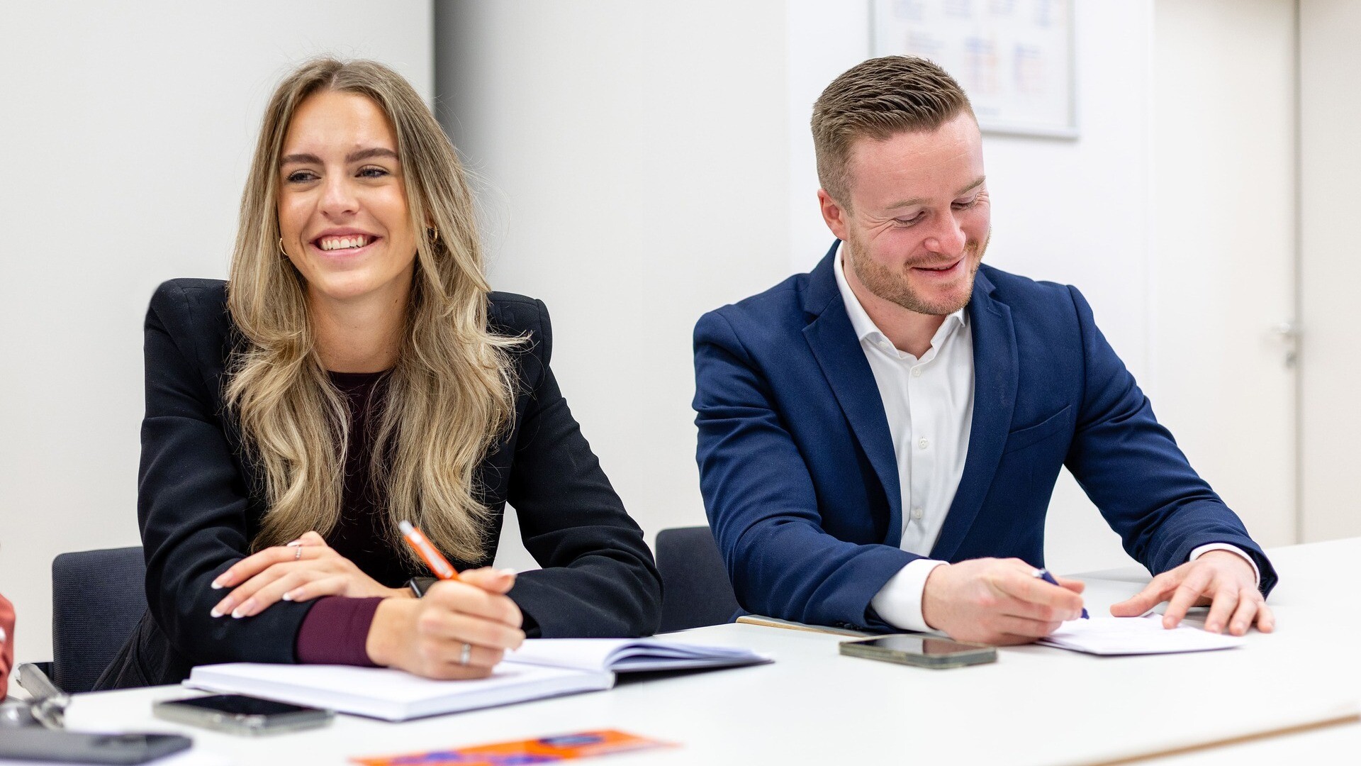 Zwei Teammitglieder sitzen nebeneinander in einer Besprechung