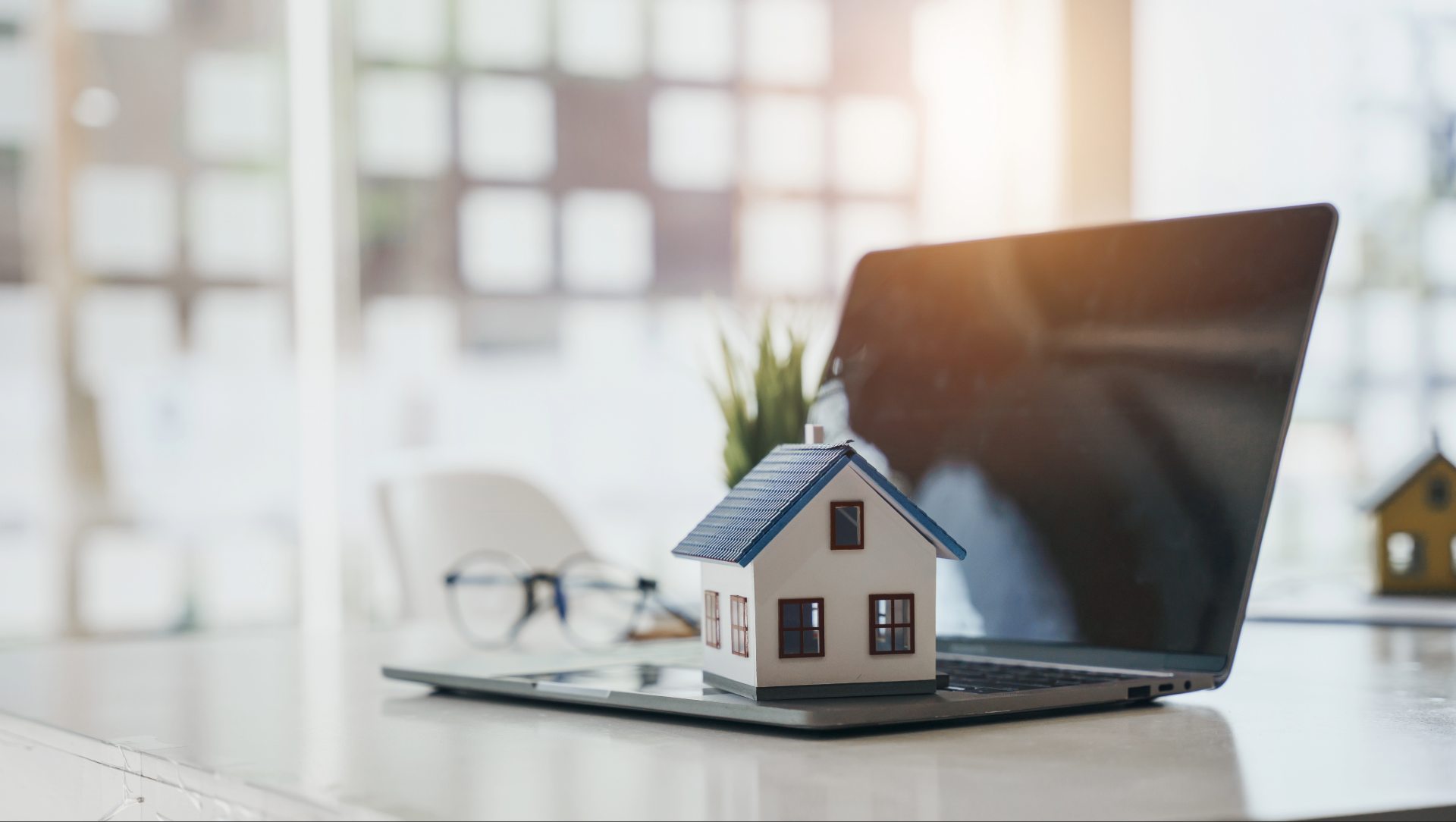 Miniaturhaus und Laptop